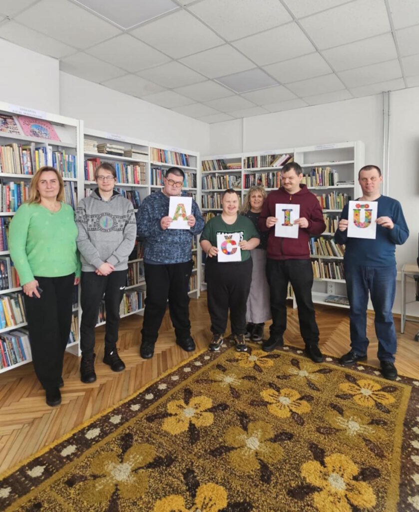 Bibliotekos lankytojai laiko užrašą Ačiū